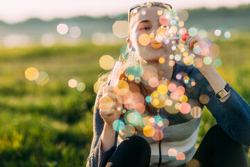 Young woman blowing soap bubbles