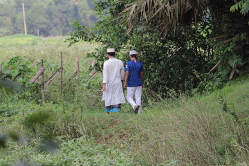 Two persons walking in the woods.