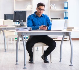 Handsome businessman employee sitting at his desk in office