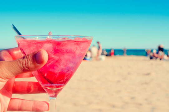 man with a cocktail on the beach