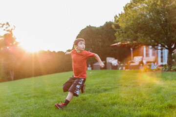Young boy playing football in a backyard