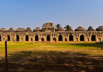  Elephant Stable in Hampi front view with blue sky in background and lawn in fore ground of the image