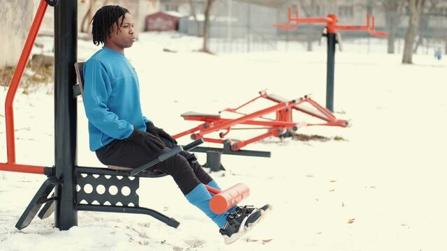 Black man doing warming up outdoors in the park in winter. Chest muscle workout, cardio workout, stretching. Increasing strength using physical activity.