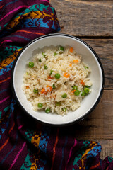 White rice with peas and carrot on wooden