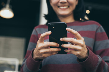 using cell phone hand holding mobile texting message contact us.chatting,search internet information in office.technology device communication connecting