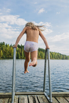 kids run and jump and skinny dip in a lake in the late summer