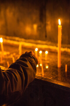 Hand light a candle in church.
