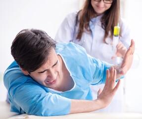 Fototapeta premium Funny man getting ready for buttocks syringe shot