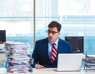 Businessman workaholic struggling with pile of paperwork