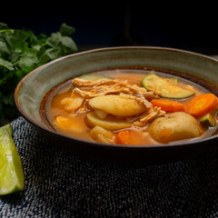 Chicken soup with rice and vegetables on wooden background