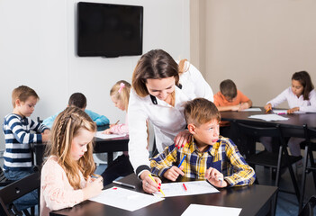 Teacher and elementary age children drawing at class