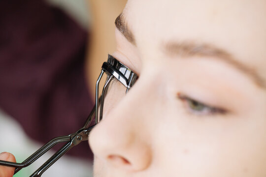Makeup artist applying eyelash curler