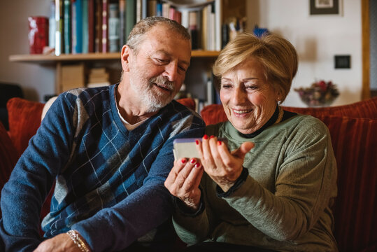 Happy senior couple using a modern phone