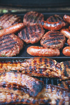 close up of meat, ribs, burgers, sausages cooking on a barbecue (BBQ)