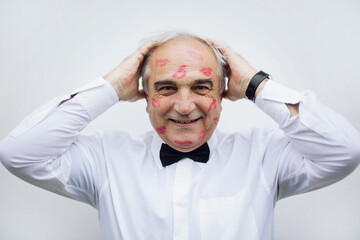 Portrait of an old man with red lip print on his face