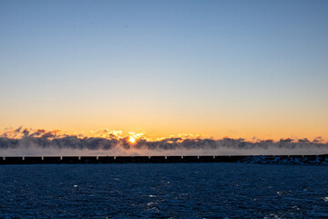 frigid sunrise over steaming lake
