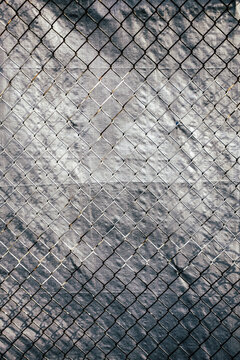 Chainlink fence in front of silver tarp
