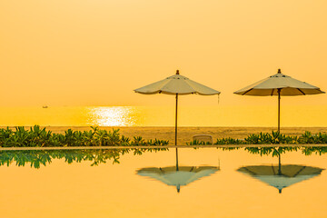 Umbrella and chair around outdoor swimming pool in hotel resort