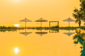 Umbrella and chair around outdoor swimming pool in hotel resort