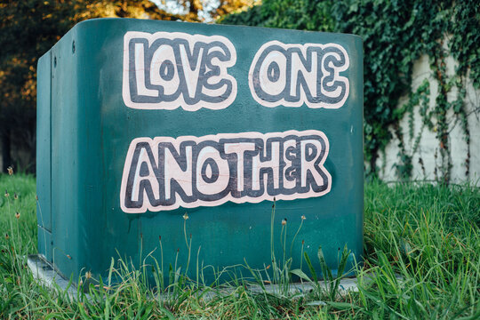 A message that says Love One Another on an electrical box