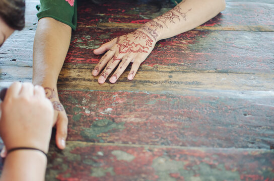 Henna tattoo being painted on hands