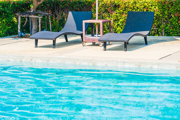 Umbrella and chair around outdoor swimming pool in hotel resort