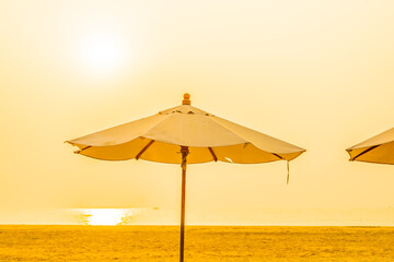 Umbrella and chair around outdoor beach sea ocean at sunset or sunrise