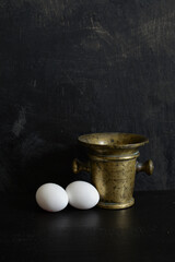 Antique brass Mortar and two white eggs