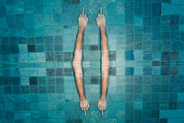 Hands showing middle finger underwater reflected of the surface