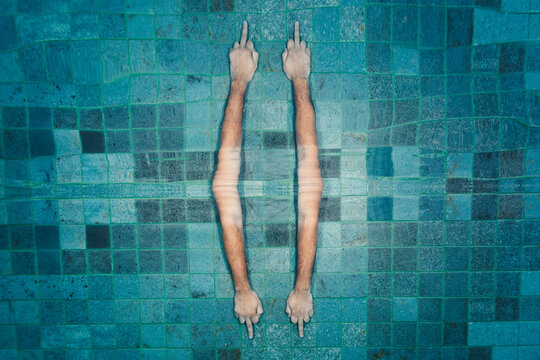 Hands showing middle finger underwater reflected of the surface