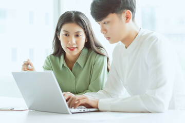 Young Asian business couple working together, completing the assigned work
