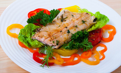 Image of fried trout fillets served with peppers and greens served at plate