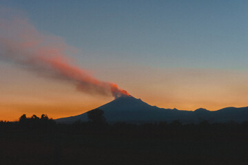 paisaje de volcanes a la luz del atardecer con colores en naranja y azules