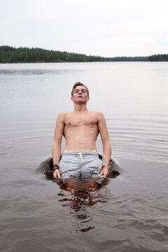 Young man falling backwards in a lake