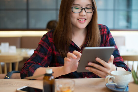 Smiling asian woman using tablet computer