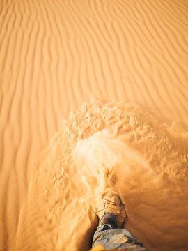 Step in the desert with sand flying away from the shoe