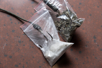 drug trap concept: a pair of drug sachets with triple hooks inside