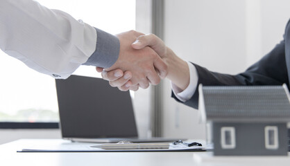 Real estate agents and customers shake hands to congratulate on signing a contract to buy a house with land and insurance, handshake and Good response concept.