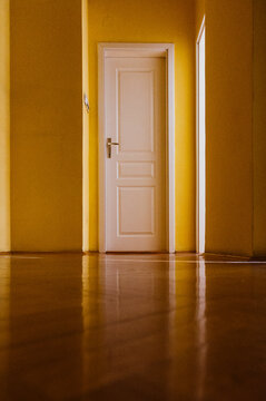 Empty hall with yellow walls and white door