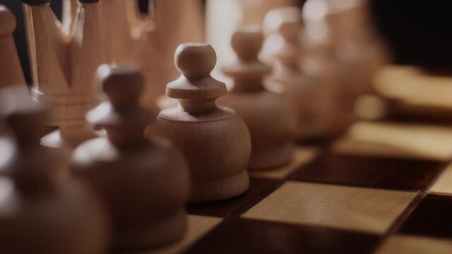 Woman playing chess, close up of lady's hand opening a game of chess. Pawn move, strategy and concentration concept. Challenge, preparation and success.