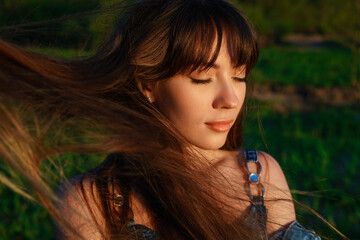 portrait of young woman with closed eyes hair fluttering in the wind