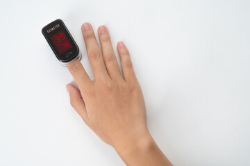 Top view of Pulse Oximeter, finger digital device to measure person's oxygen saturation. Reduced oxygenation is an emergency sign of pneumonia caused by flu or novel coronavirus. Device on Fingertip