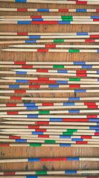 Mikado game. Colorful wood sticks on old wooden background.