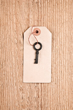 Old key and tag with blank space on wood background.