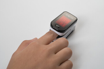 Pulse Oximeter, finger digital device to measure person's oxygen saturation. Reduced oxygenation is an emergency sign of pneumonia caused by flu or novel coronavirus. Device on Fingertip