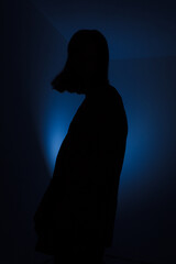 silhouette of a person in a room with blue background