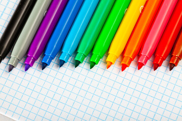 Image of opened multicolored markers on notebook, nobody