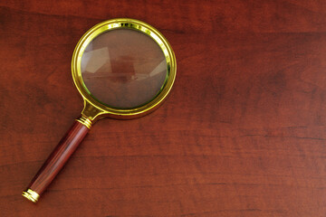 Magnifying glass on wooden table with room for text