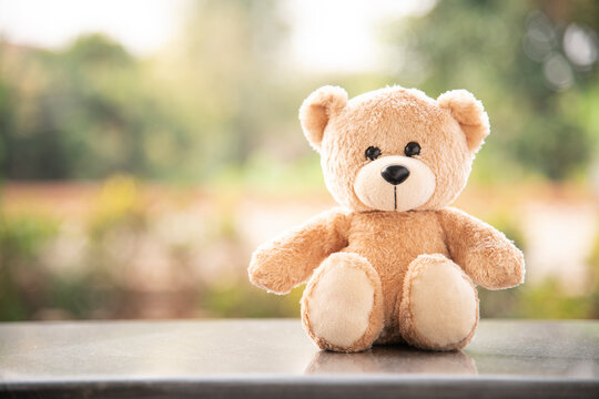 Naklejki Teddy bear on wooden and blurred background 