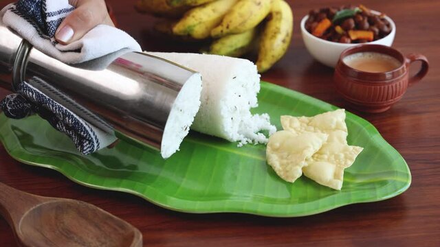 Rice Puttu white Pittu , Kadala Chickpea curry , milk tea , popular South Indian breakfast steamed rice cake 4K slow motion video footage Kerala Tamil Nadu India Sri Lanka. rice flour grated coconut  